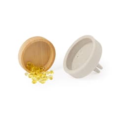 A bamboo container spills yellow capsules beside a ceramic plug-in freshener. Both items are in neutral tones.
