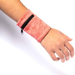 A silicon wristband in bright pink with a zippered pocket, worn on a wrist. The product features a textured design.