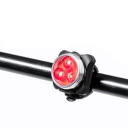 A red bike light with three LEDs attached to a black handlebar mount. The product features a simple design.