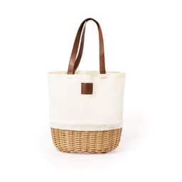 A cream and woven wicker picnic basket with brown leather handles and a simple logo patch.