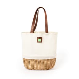 A cream canvas picnic basket with a woven bottom and brown leather handles, featuring a small green square detail.