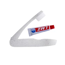 A white speckled folding toothbrush and a small tube of toothpaste, featuring a logo.
