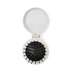 A compact mirror with a black bristle hairbrush inside, featuring a light-coloured outer casing.