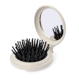 A compact hairbrush with a mirror, featuring a light grey case and black bristles. It has a circular design.