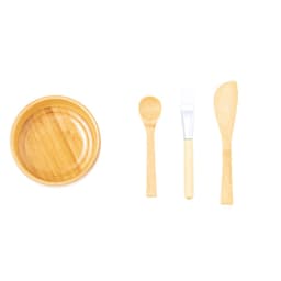 A bamboo bowl with a smooth finish, accompanied by a wooden spoon, a spatula, and a spreading knife.