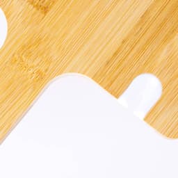 A bamboo chopping board featuring a white accent, showcasing a smooth surface and rounded edges.