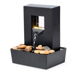 A black indoor water fountain featuring a sleek design, flowing water, and decorative stones in the base.