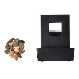 A black water fountain with a square design and a collection of small, smooth pebbles beside it.