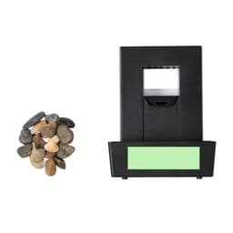 A black water fountain with a stone base, accompanied by a small pile of pebbles. It features a branding logo.