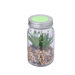 A decorative plant in a clear jar with pebbles, featuring green artificial leaves and a silver lid.
