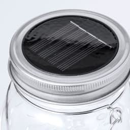 A glass lamp with a silver lid featuring a solar panel on top. The design is sleek and modern.