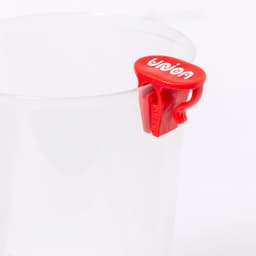 A transparent plastic cup with a red branding clip attached, featuring a logo on the clip.