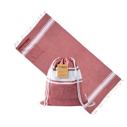 A maroon drawstring bag with a white stripe, positioned next to a matching maroon towel featuring fringed edges.