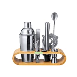 A cocktail set featuring a silver shaker, strainer, stirrer, and jigger, presented on a bamboo storage stand.