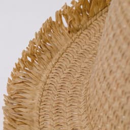 A straw hat with a wide brim and frayed edges, showcasing a natural beige colour and textured weave.
