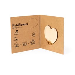 A heart-shaped seed paper inside a brown kraft card with planting instructions for field flowers and illustrations.