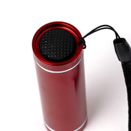 A red cylindrical torch with a textured black top, featuring a black lanyard for carrying.