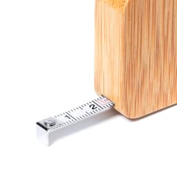 A bamboo tape measure with a silver metallic end, partially extended, showcasing its measurement markings.