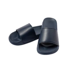 A pair of navy blue thongs with a simple strap design, featuring a logo on one of the thongs.