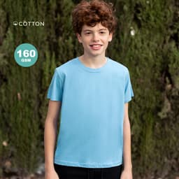 A blue cotton t-shirt for kids, displayed on a model with curly hair in front of greenery. The shirt features a logo.