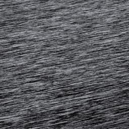 A textured grey fabric of a Kassar T-Shirt, featuring a subtle heather pattern and a branding logo.
