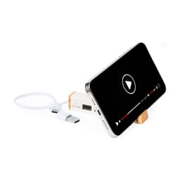 A USB drive in white and wood, attached to a phone stand, with a smartphone displaying a video.