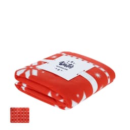 A folded, red Yalanny blanket with white snowflake patterns, featuring a logo and a small image of a matching design.