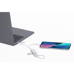 A white USB hub connected to a laptop, with a smartphone being charged via a cable.