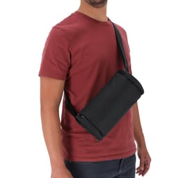 A black Koket Bag with an adjustable strap, worn across the body by a person in a red shirt.