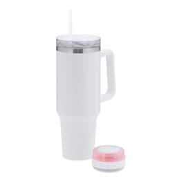 A white insulated travel mug with a handle and a straw, accompanied by a small round Bluetooth speaker.