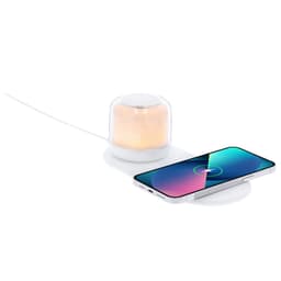 A wireless charger in white with a soft glow, placed beside a smartphone on a flat surface, featuring a logo.