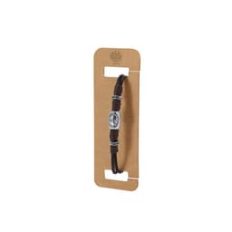 A brown bracelet featuring a metallic charm and decorative accents, displayed on a cardboard backing with branding.