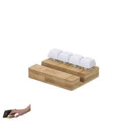 A bamboo phone stand with four white, textured holders for devices and a smooth base for stability.