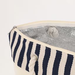 A striped insulated bag in navy and cream, featuring a silver interior lining and rope handles.
