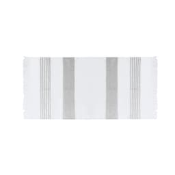 A white beach towel with light grey stripes, featuring fringed edges and a logo. Ideal for leisure and outdoor use.