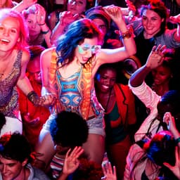 A vibrant party scene with diverse individuals dancing energetically under colourful lights. The atmosphere is lively and festive.