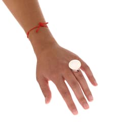 A hand wearing a large silver ring and a red string bracelet. The ring features a smooth, round surface.