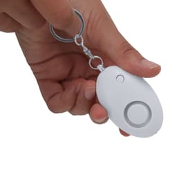 A keychain device held in a hand, featuring a white rounded shape with a button and a metal loop.