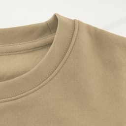 A close-up of a tan hoodie featuring a crew neck design and smooth fabric texture. It has a logo on it.