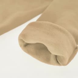 A close-up of a beige hoodie sleeve, featuring a soft, fleecy texture and rolled cuff. The image includes a logo.