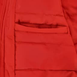 A close-up of a bright red puffer jacket featuring a zip and a small pocket on the inside.
