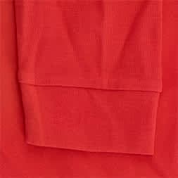 A red polo shirt featuring a textured fabric with a folded sleeve, also displaying a logo.