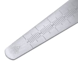 A stainless steel ruler featuring measurements, with markings for inches and centimetres. It has a sleek, metallic finish.