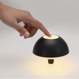 A black decorative lamp with a dome shape and warm light, featuring a touch sensor on the top.