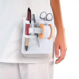 A white mesh pocket holds a pen, scissors, a spool of tape, and a stick pen, attached to a person's clothing.