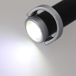 A black torch with a silver holder, emitting a bright white light. It features a circular light head.