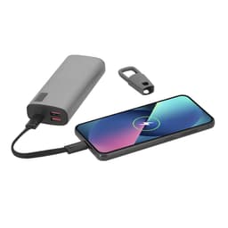 A grey charging power bank connected to a smartphone, with a charging cable and an accessory clip beside it.