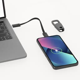A charging cable connects a black smartphone to a laptop, with a logo visible on the cable.