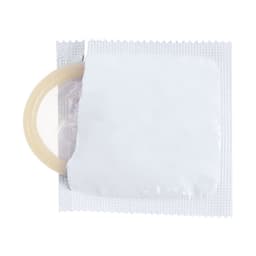 A packaged condom with a beige ring visible through a white wrapper. The wrapper has a smooth texture and no branding.