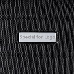 A textured black wheeled bag featuring an embedded logo label in a silver rectangular patch.